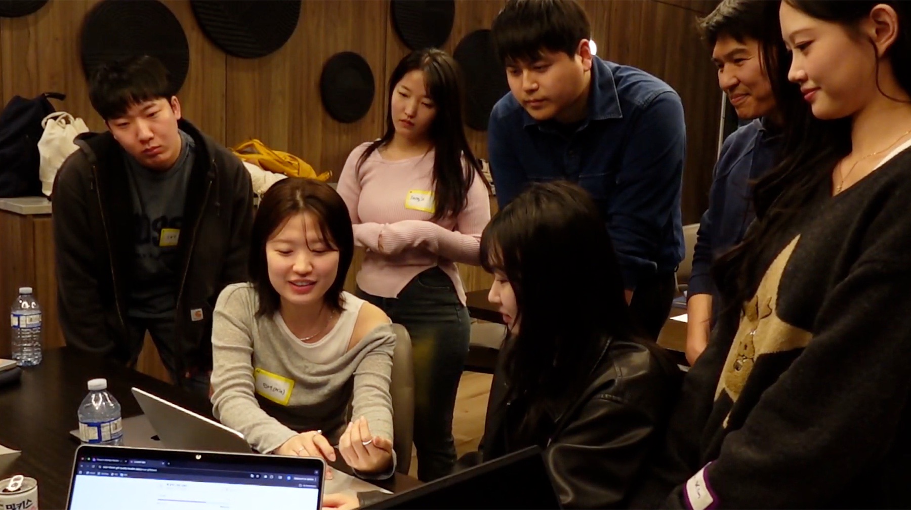 Designers gathered around laptops while building and reviewing a prototype during the mini hackathon